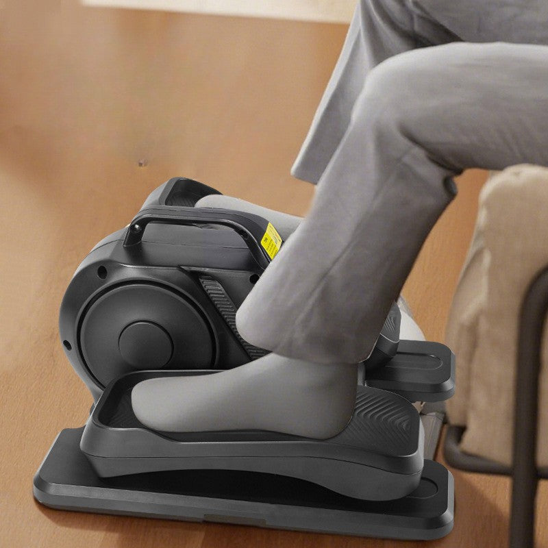 Person using a compact exercise bike on a wooden floor